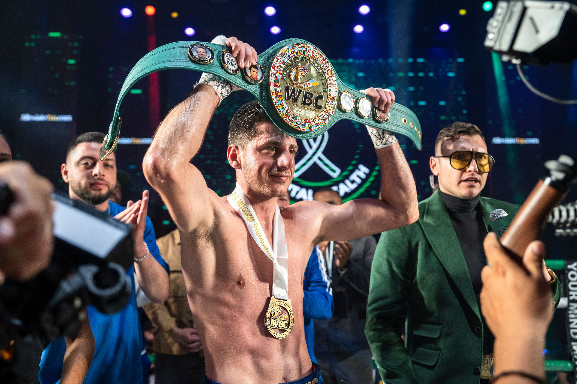 Jonny Mansour holding the WBC championship belt overhead after a victory